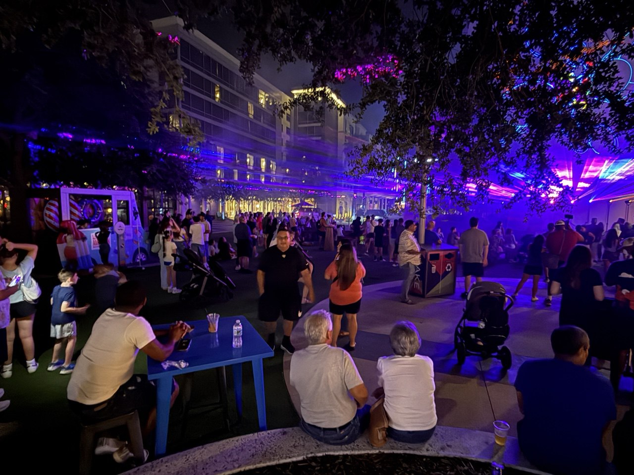 Families and friends gathered under blue laser glow at Lake Nona Town Center
