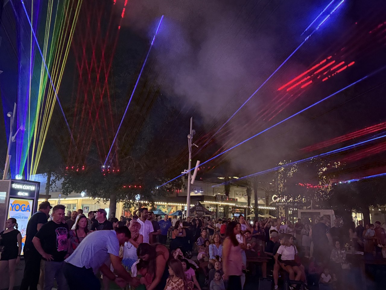 Rainbow laser beams over hundreds of attendees — families, kids, and friends