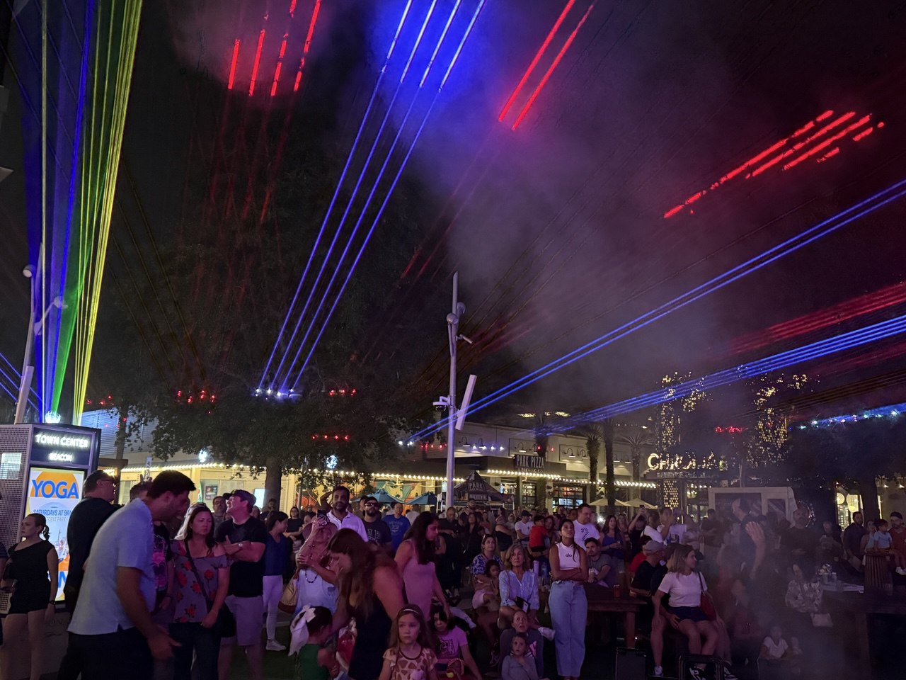Red and blue patriotic laser beams over the 4th of July celebration crowd