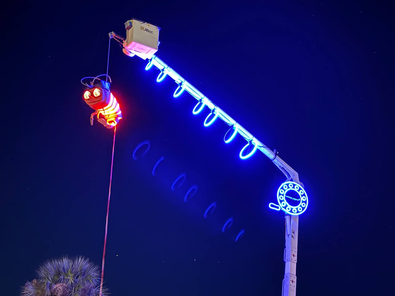Close-up of Shrimpy glowing on the crane against the night sky