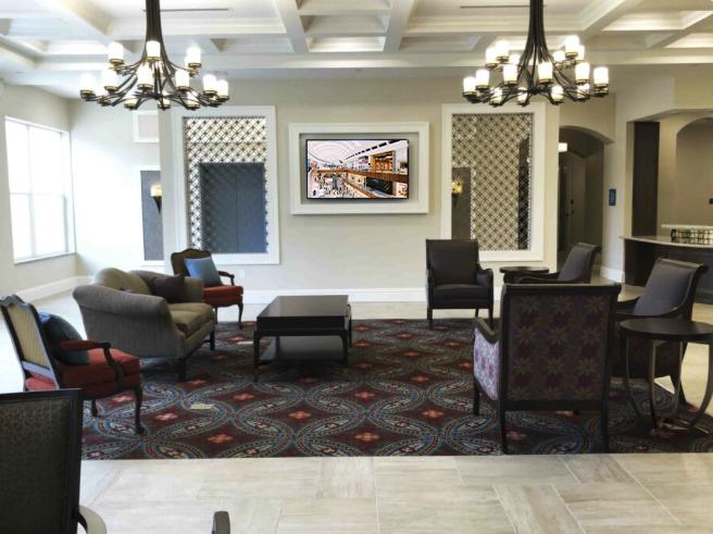 Palagio Senior Living elegant lobby with chandeliers and wall-mounted display